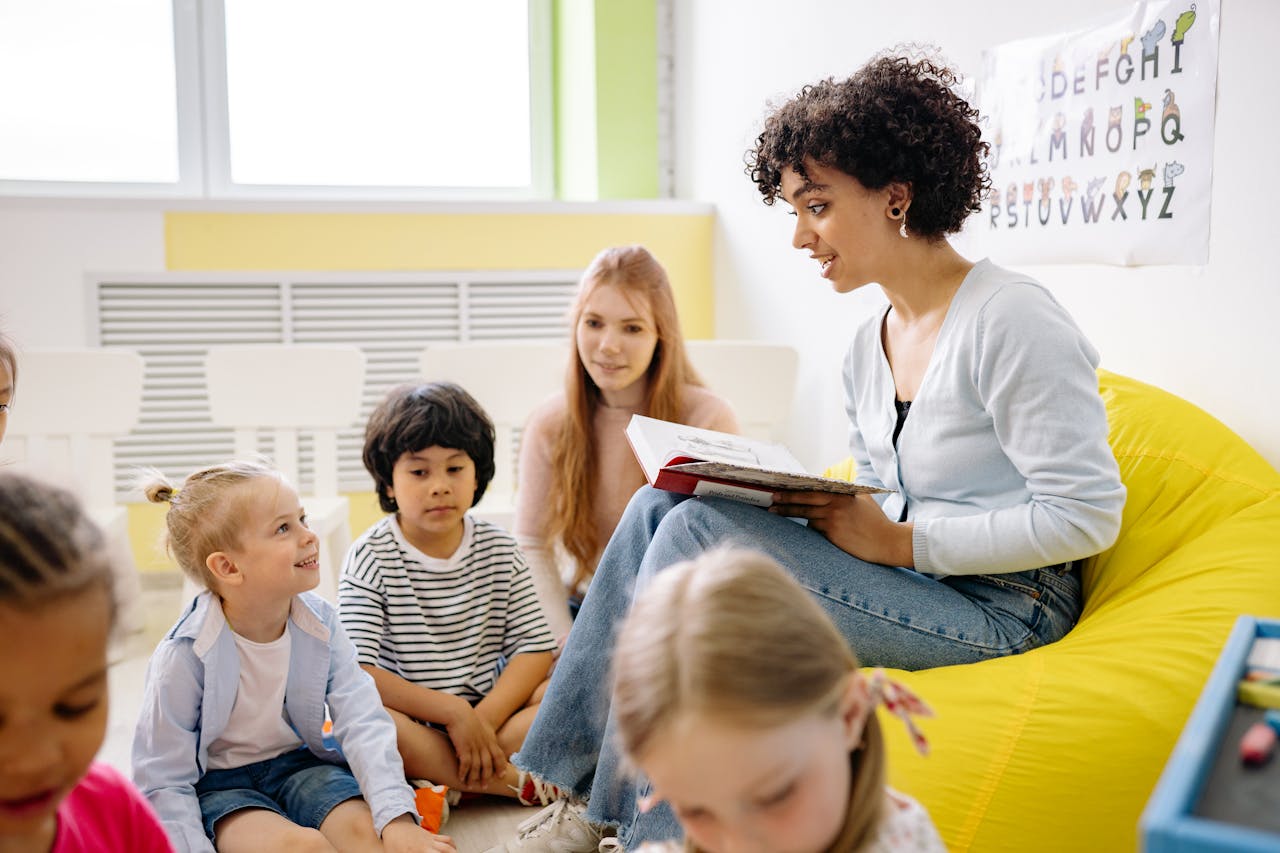 gallery-02 Teacher reading to preschool kids in a colorful classroom setting.